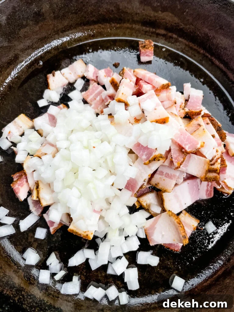 raw onions and bacon in a cast iron skillet