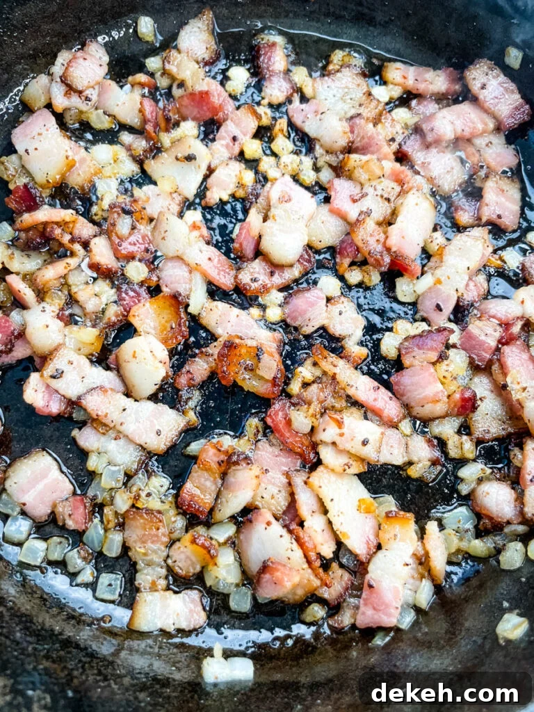 cooked bacon and onions in a cast iron skillet