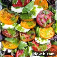 Insalata caprese with fresh mozzarella and basil dressing on serving platter.