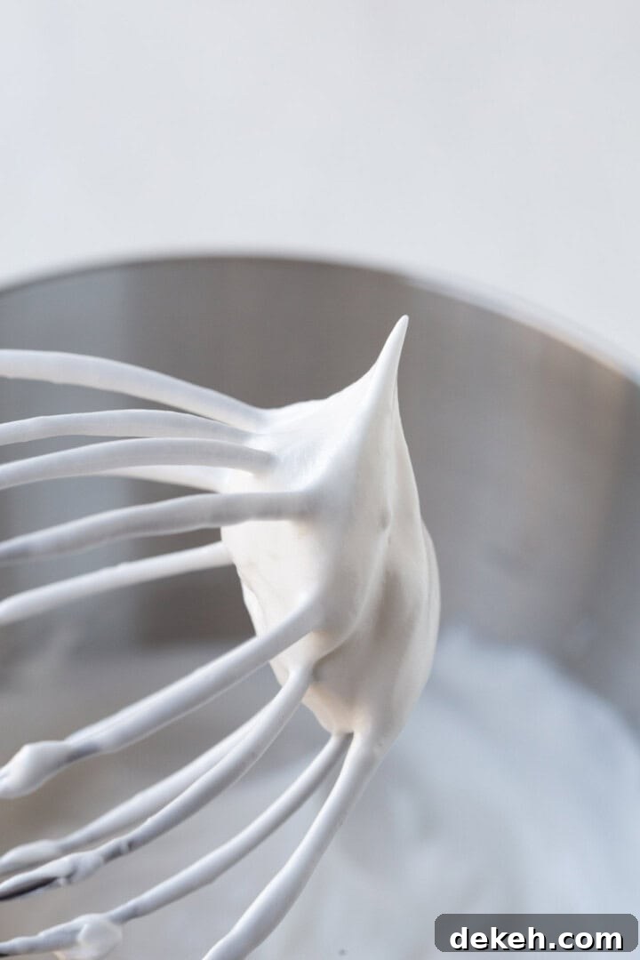 whipped meringue on a beater with a stiff peak.