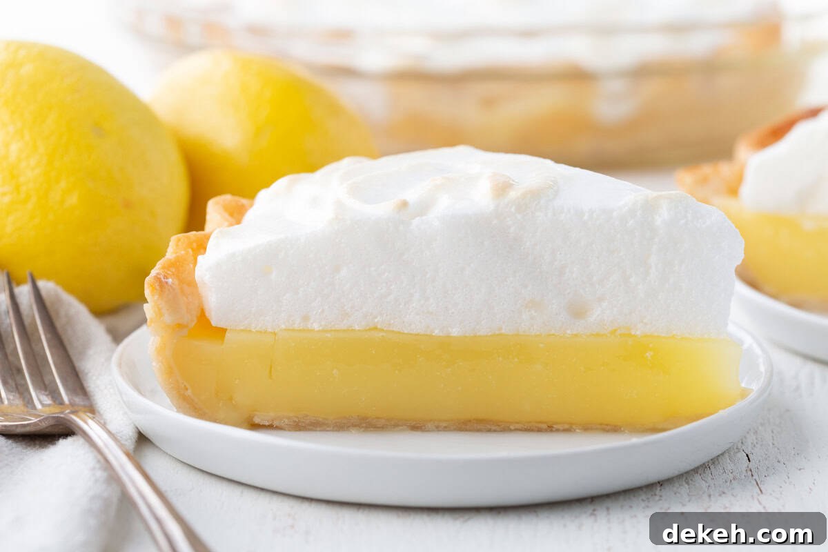slice of lemon pie with a yellow lemon layer topped with a fluffy meringue.