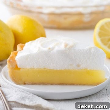 slice of lemon pie with a yellow lemon layer topped with fluffy meringue.