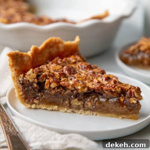 slice of old fashioned pecan pie on a white plate.