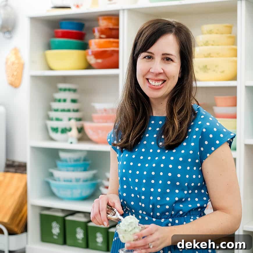 woman scooping pistachio salad into a parfait dish, with colorful vintage bowls in the background.