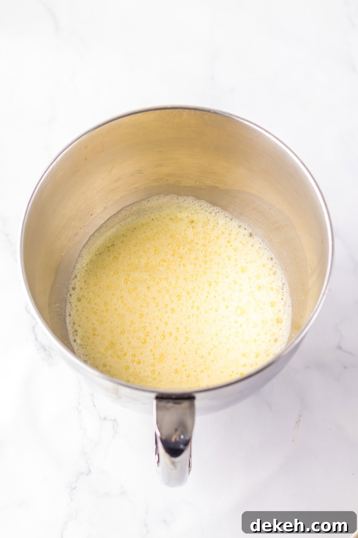 An overhead image of beaten eggs in a large bowl.