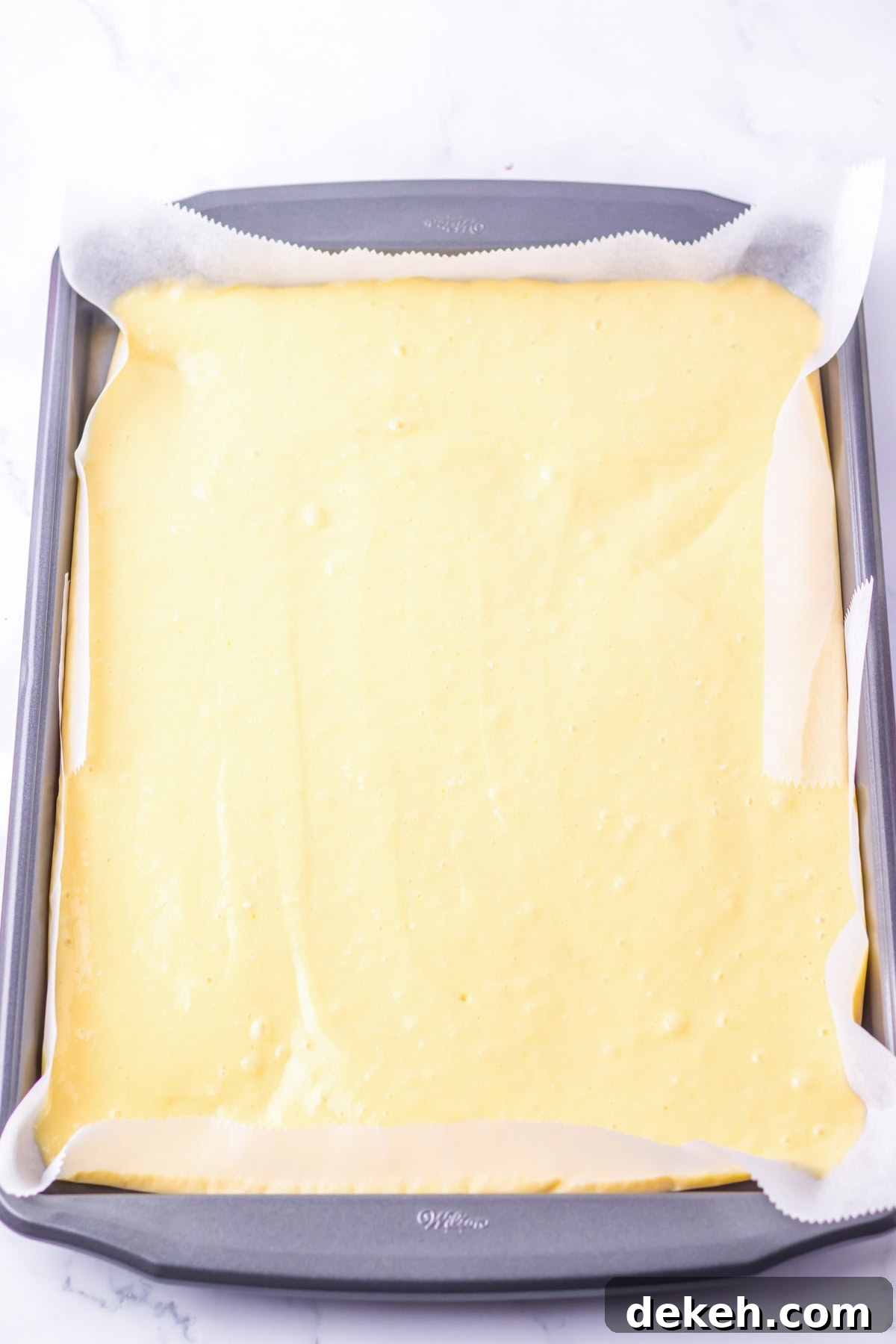 An overhead image of transferring the batter to a pan.