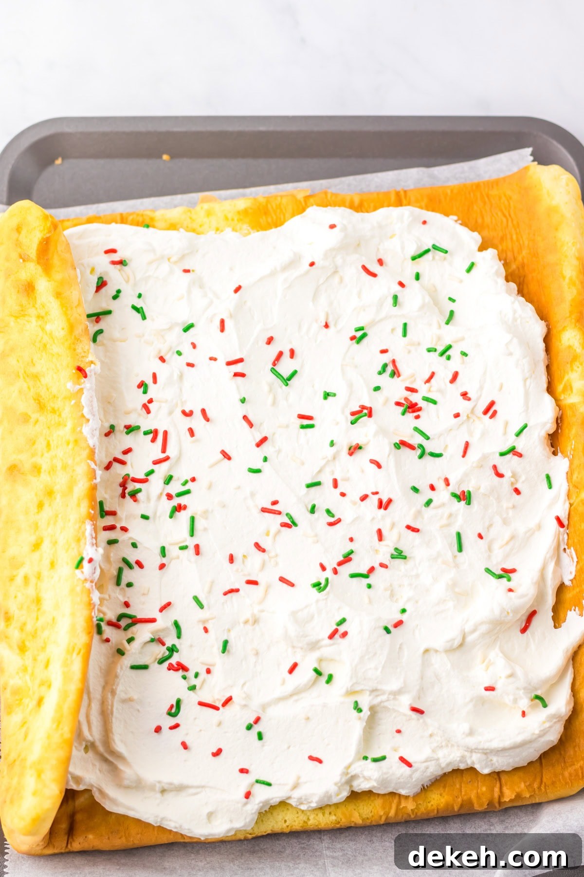 An overhead image of spreading the frosting inside the cake roll.