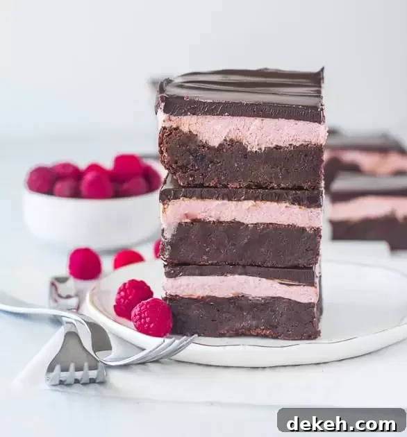stack of raspberry brownies on a plate with two forks next to it