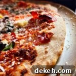 baked pizza on pizza pan showing golden crust