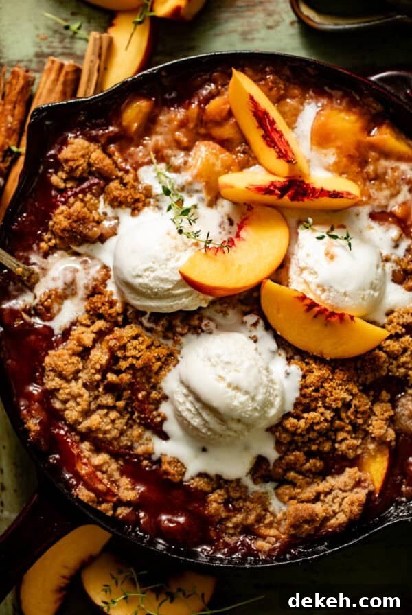peach crumble in a cast iron skillet topped with ice cream.