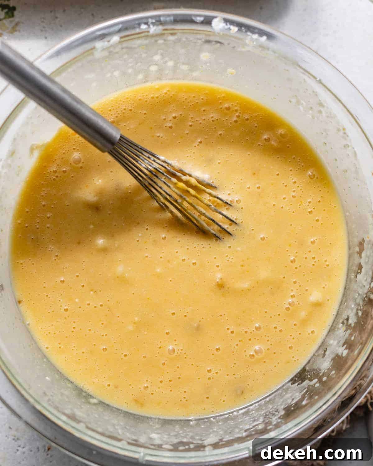 wet ingredients mixed together in a bowl with a whisk.