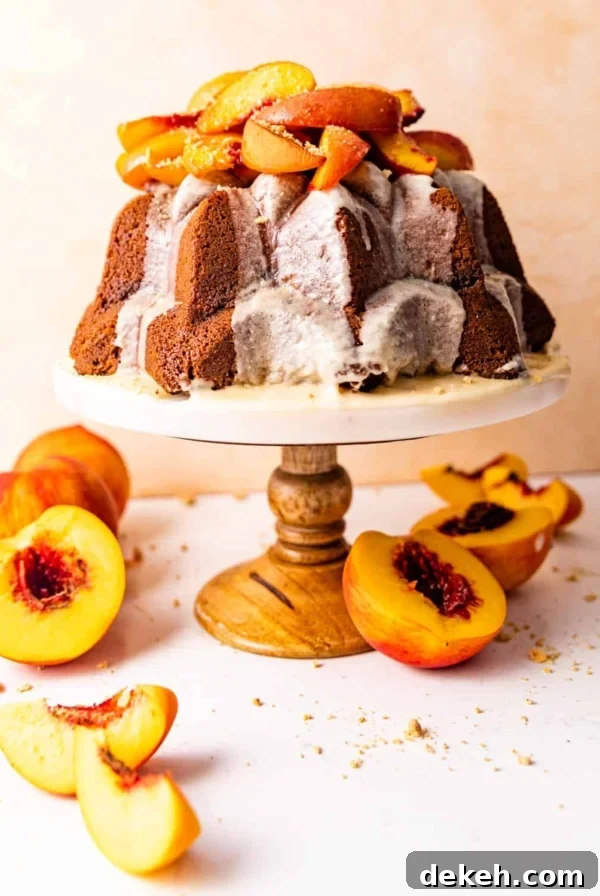 pound cake on a cake stand topped with roasted peaches.
