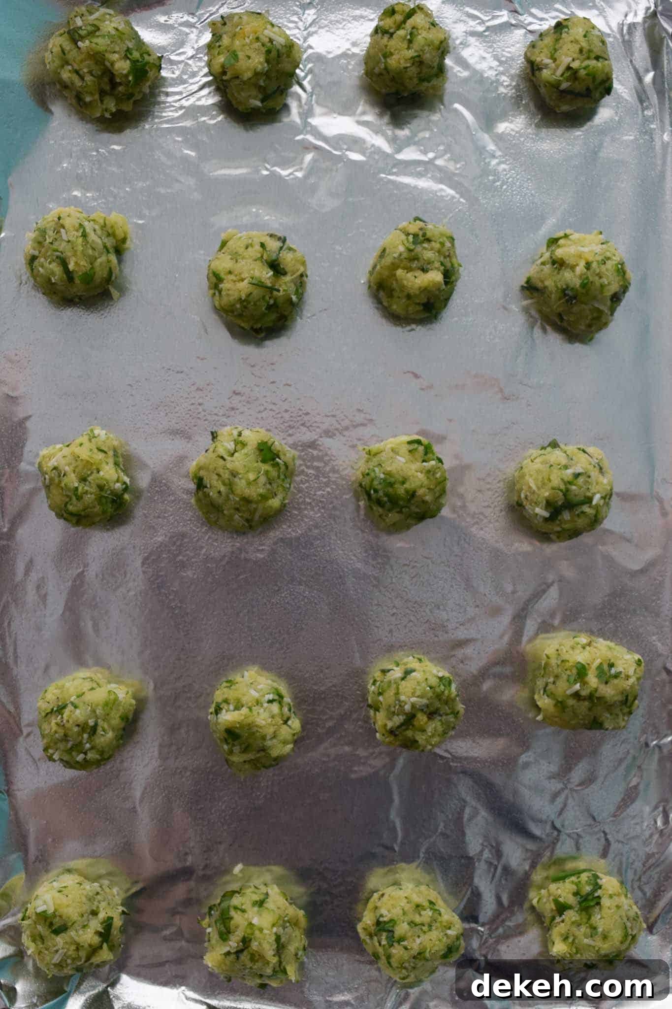 Zucchini Garlic and Herb Bites on baking sheet lined with foil overhead shot