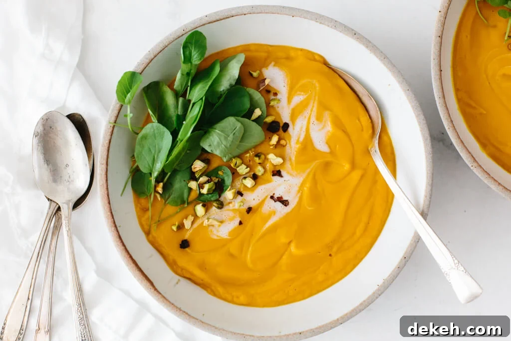 Sweet potato soup in a white bowl with a spoon.