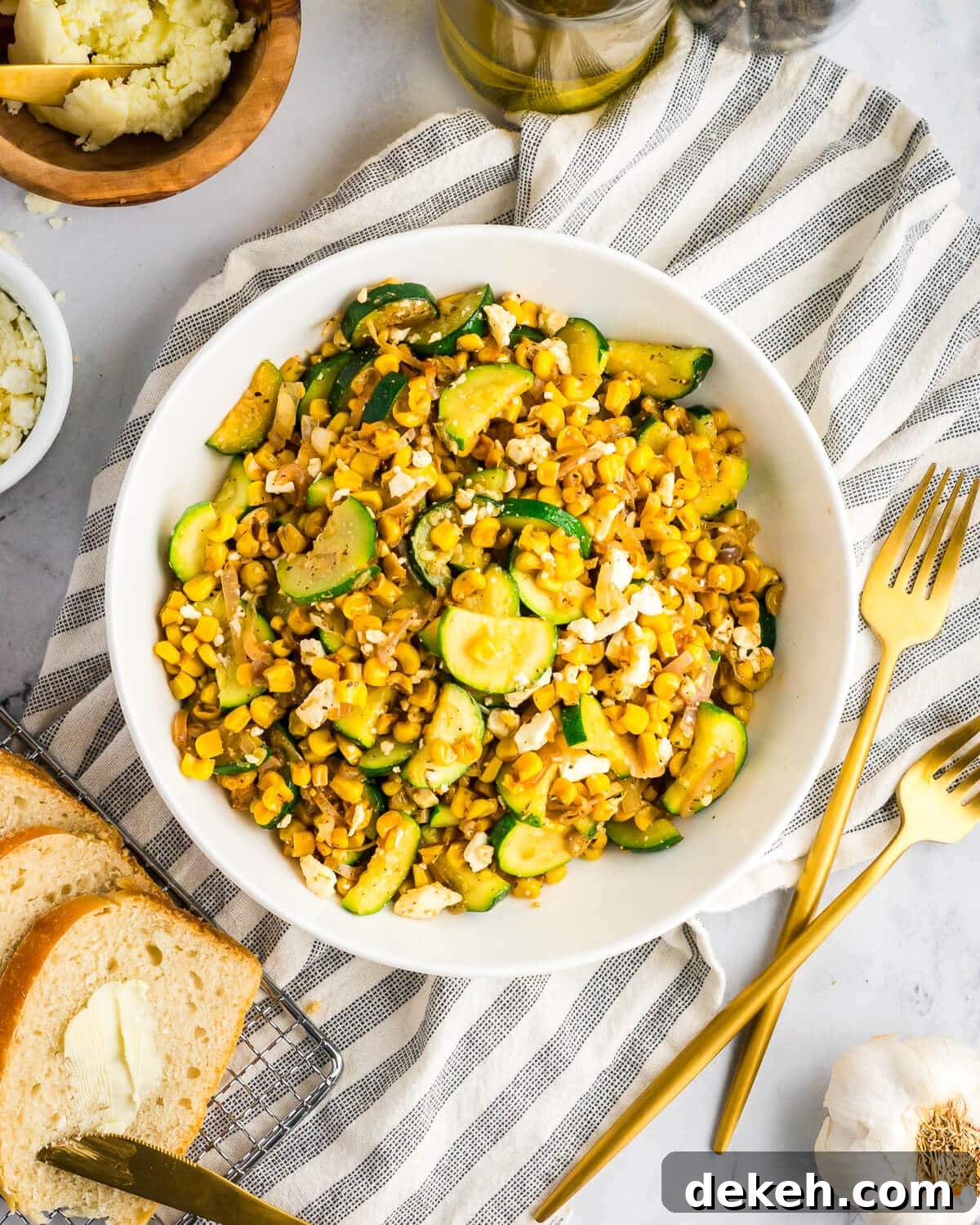 a bowl of sauteed corn, zucchini, feta, and shallots. 