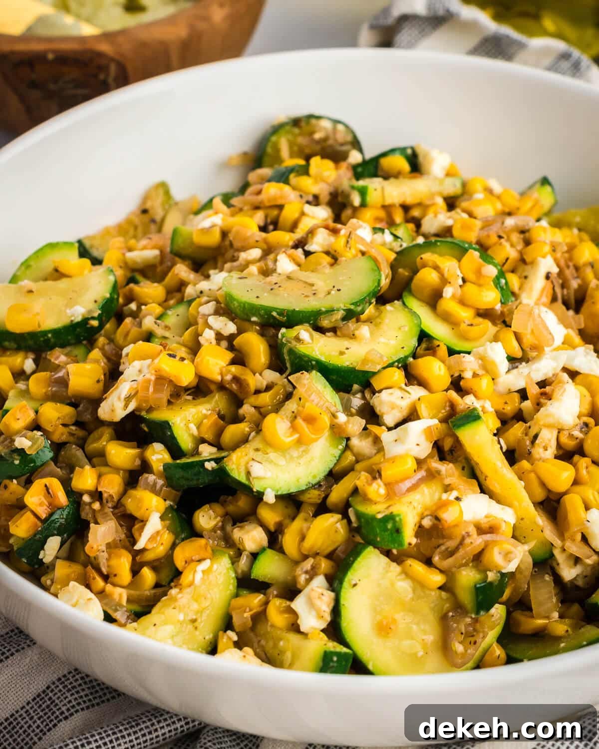 a bowl of sauteed zucchini, feta, and shallots in a bowl. 