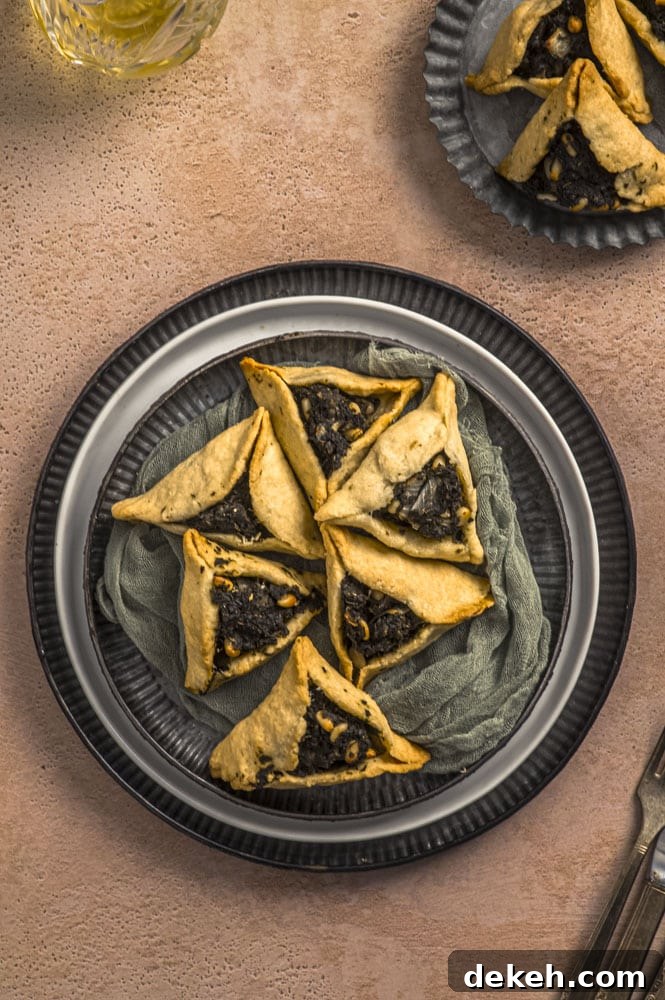Overhead view of two stacked plates with fatayer, lebanese pies
