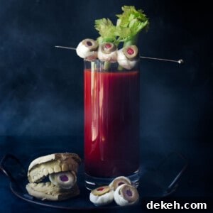Bloody Mary with celery and mozzarella garnish on a black background.