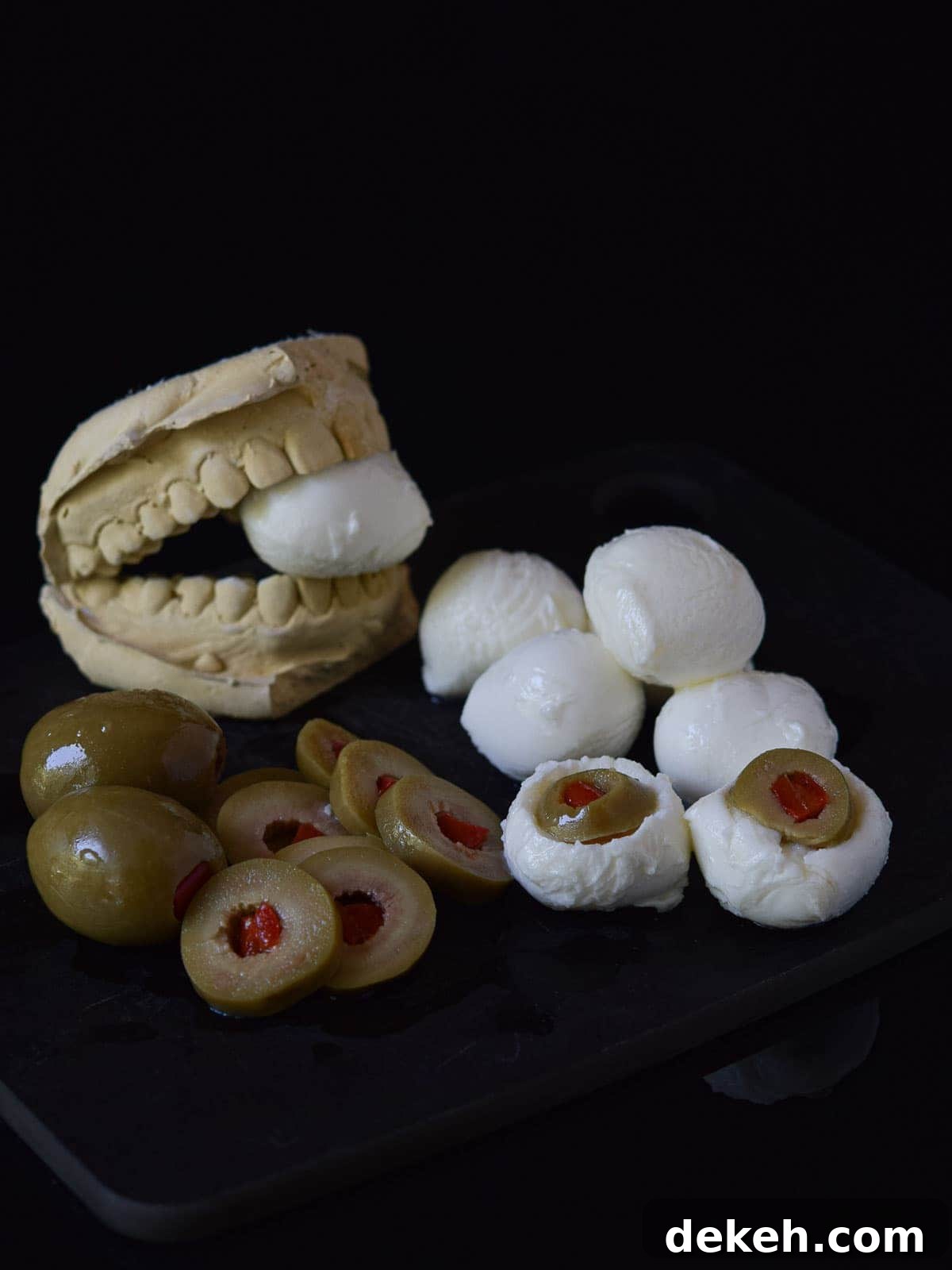 Mozzarella balls with olives are cut out with the olive inserted into the mozzarella.
