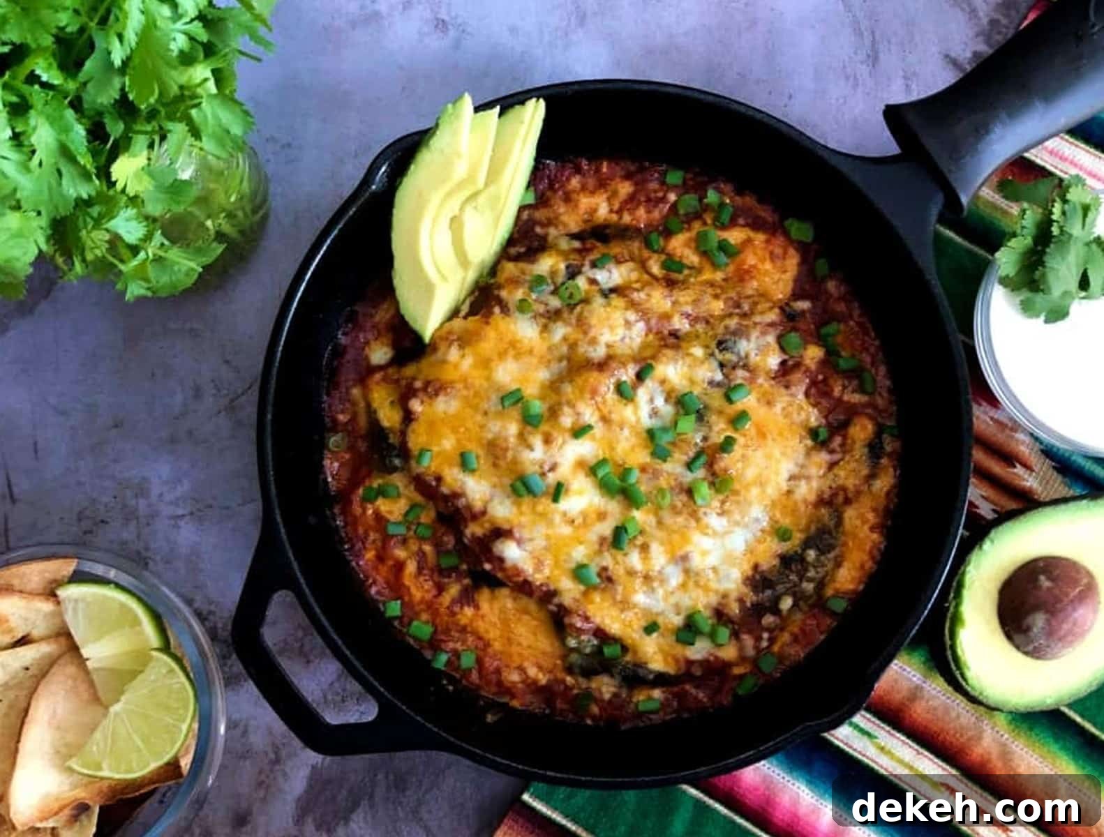 baked chile rellenos in a pan with green onions on top.
