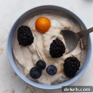 Creamy Dairy-Free Fruit Dip Recipe for Parties and Snacks 3 Dairy-free fruit dip topped with blackberries, blueberries, and a golden berry in a small bowl.
