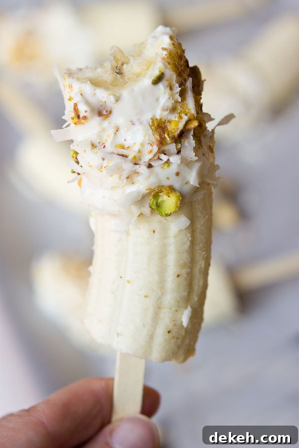 Banana Crunch Pops on a stick, coated with yogurt, pistachios and coconut