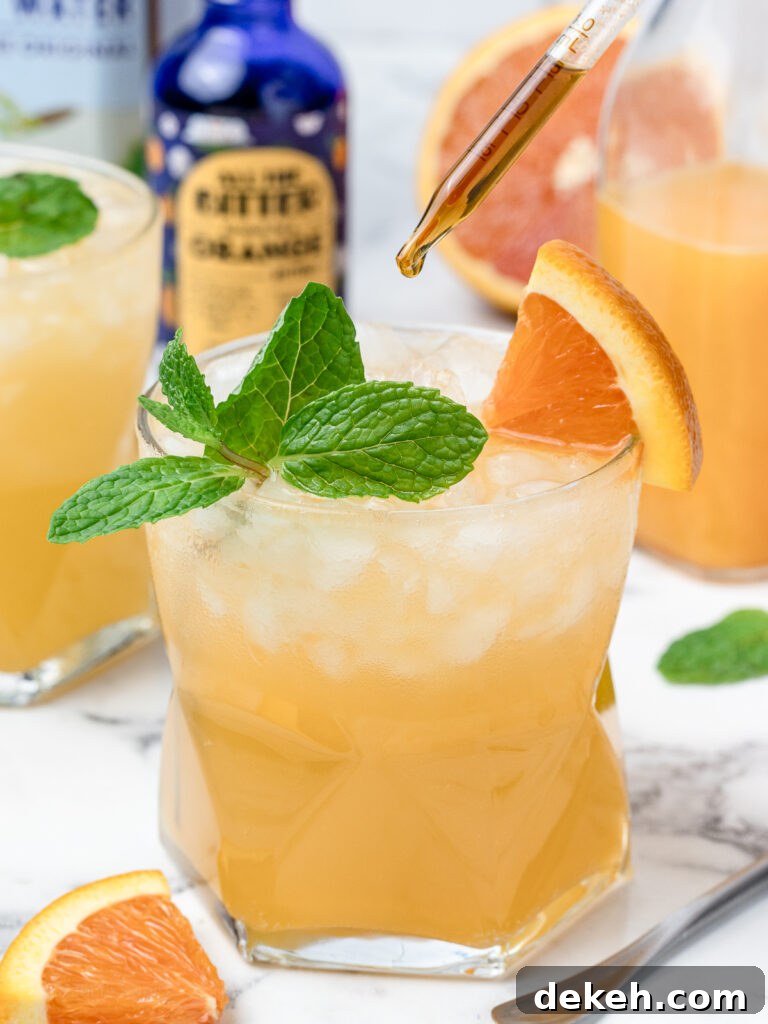 Adding an extra dash of alcohol free orange bitters to the orange and coconut water mocktail.