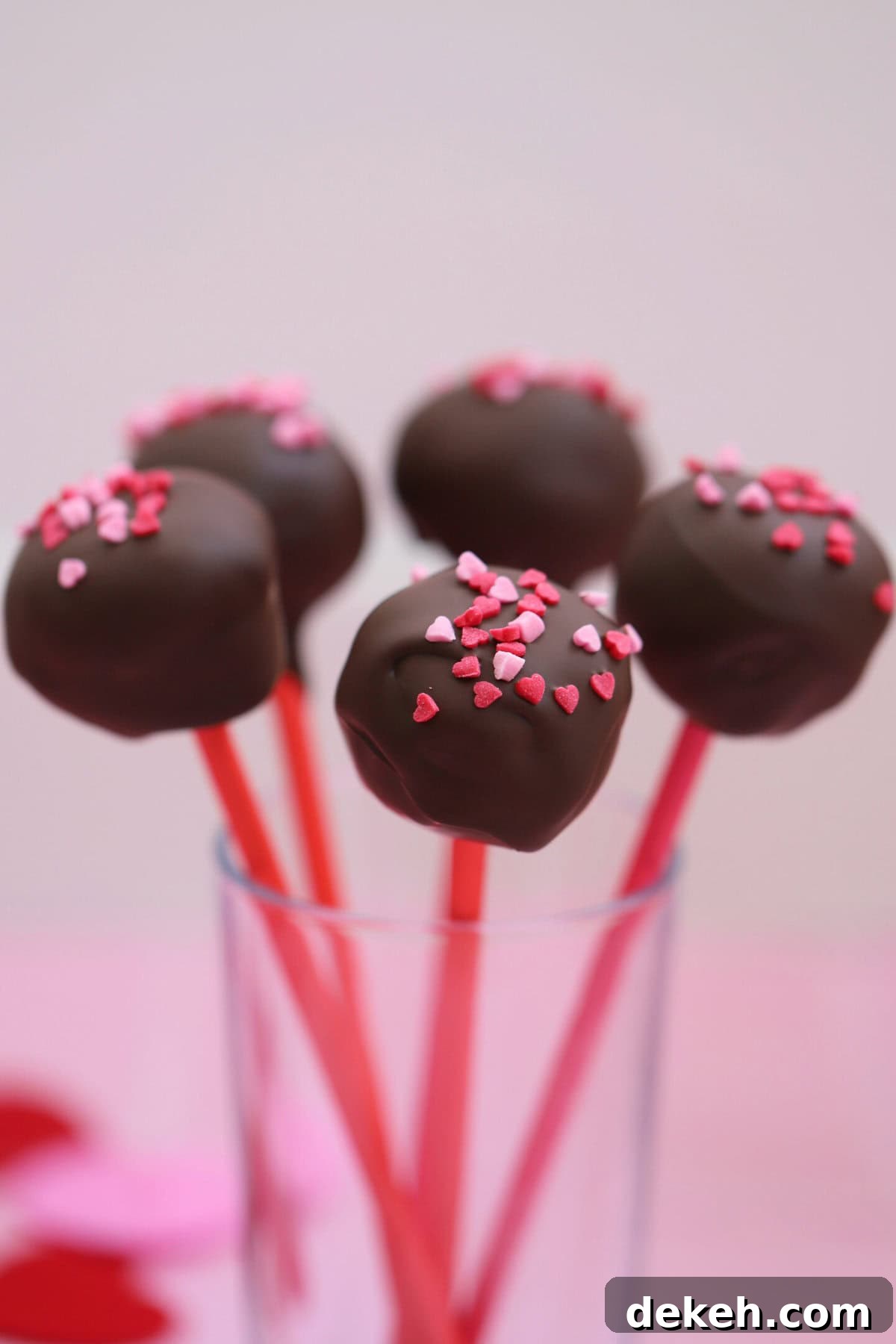 Gluten free cake pops in a glass against a white background.