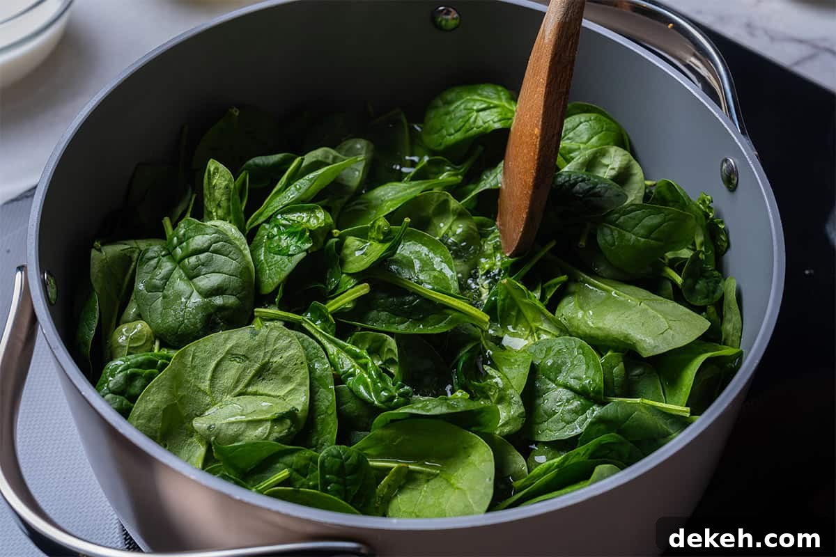 pot with spinach and a wooden spoon touching the top