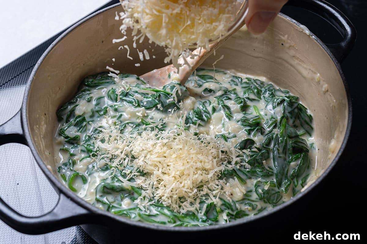 easy creamy spinach in a pot having cheese sprinkles over it