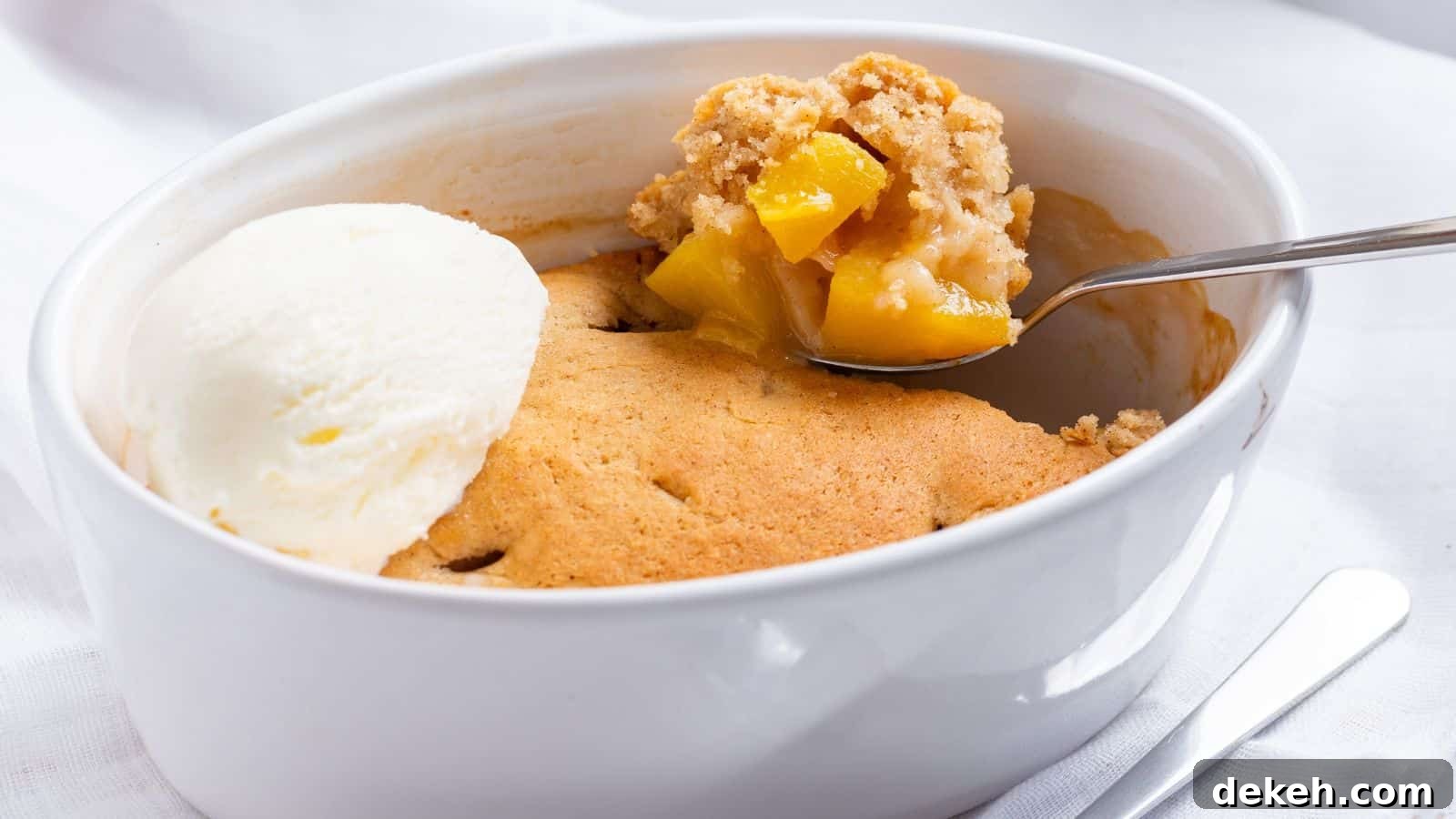 Peach cobbler with ice cream and peaches.