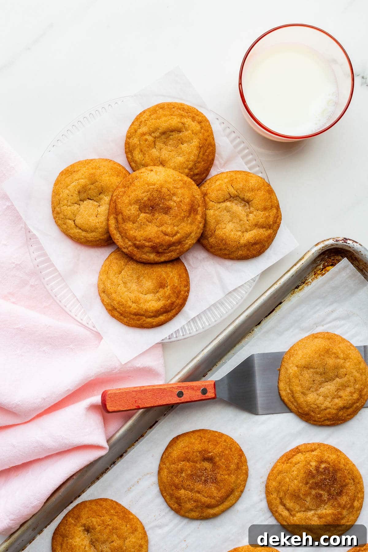 Transferring freshly-baked homemade snickerdoodles to a plate to serve them.