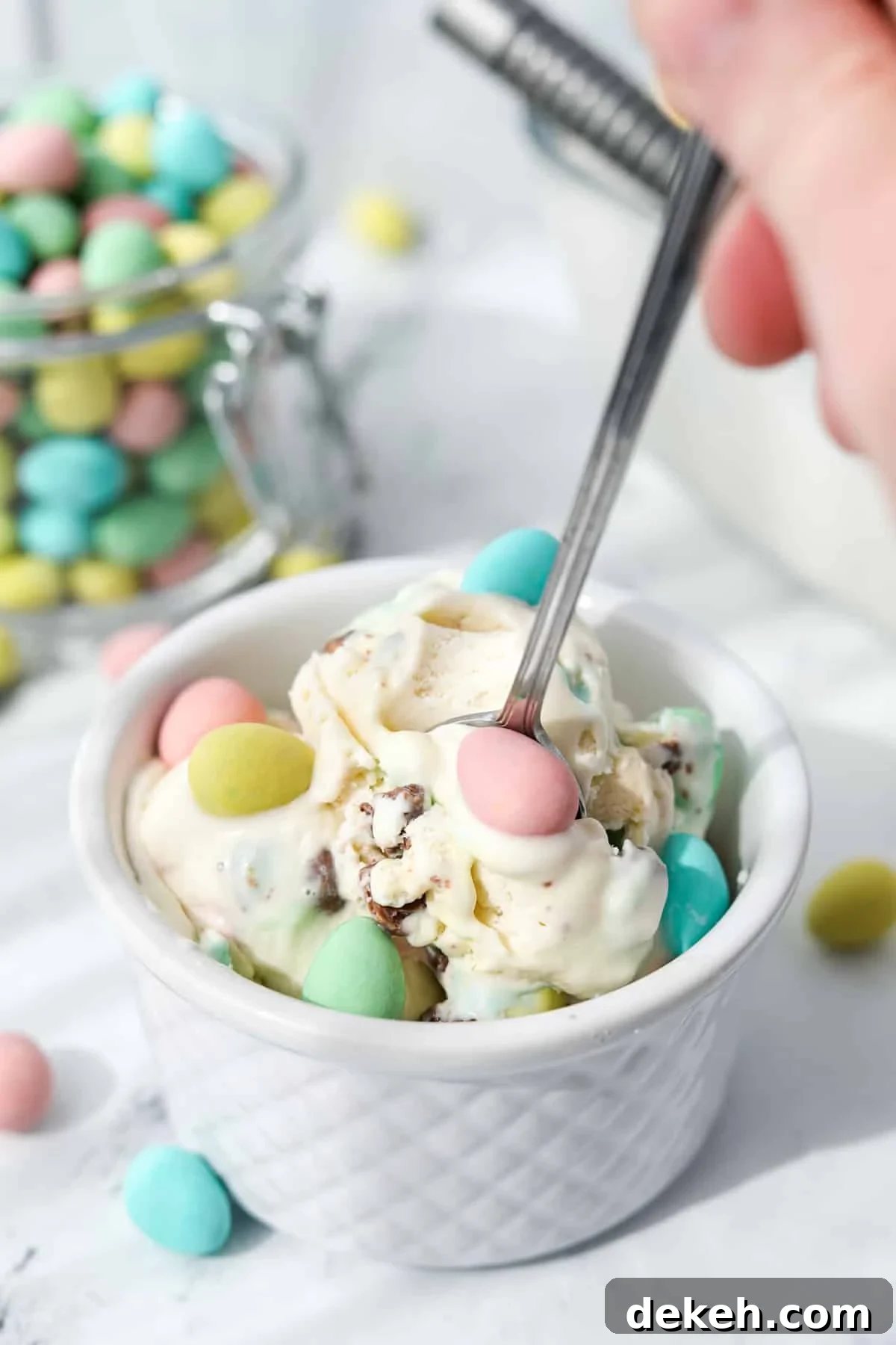 Using a spoon to take a portion of homemade mini egg ice cream from a bowl.
