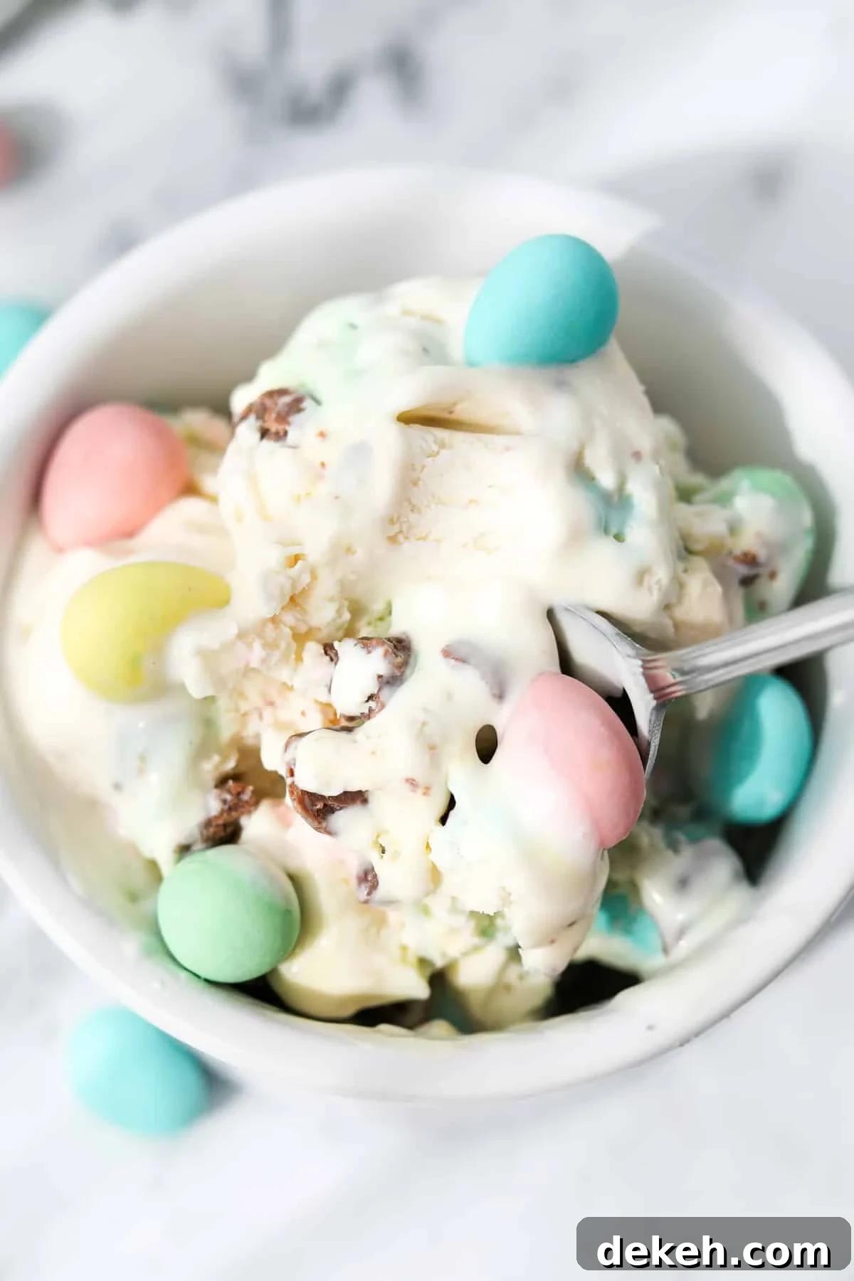 A spoon inside of a small bowl of ice cream.