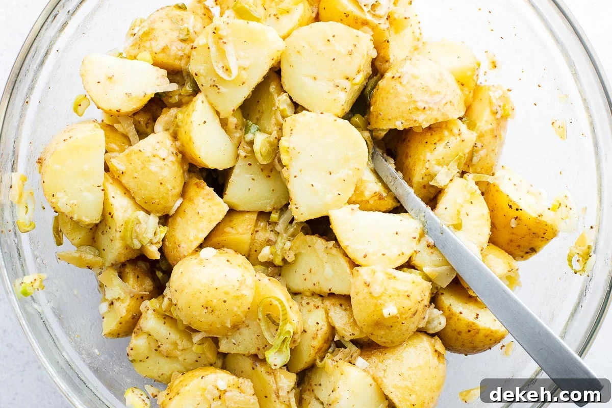 Just cooked potatoes getting mixed with a preserved lemon and mustard dressing.