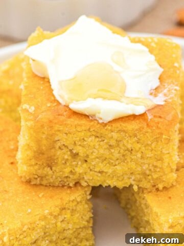 Up close view of almond flour cornbread topped with whipped cream and honey.