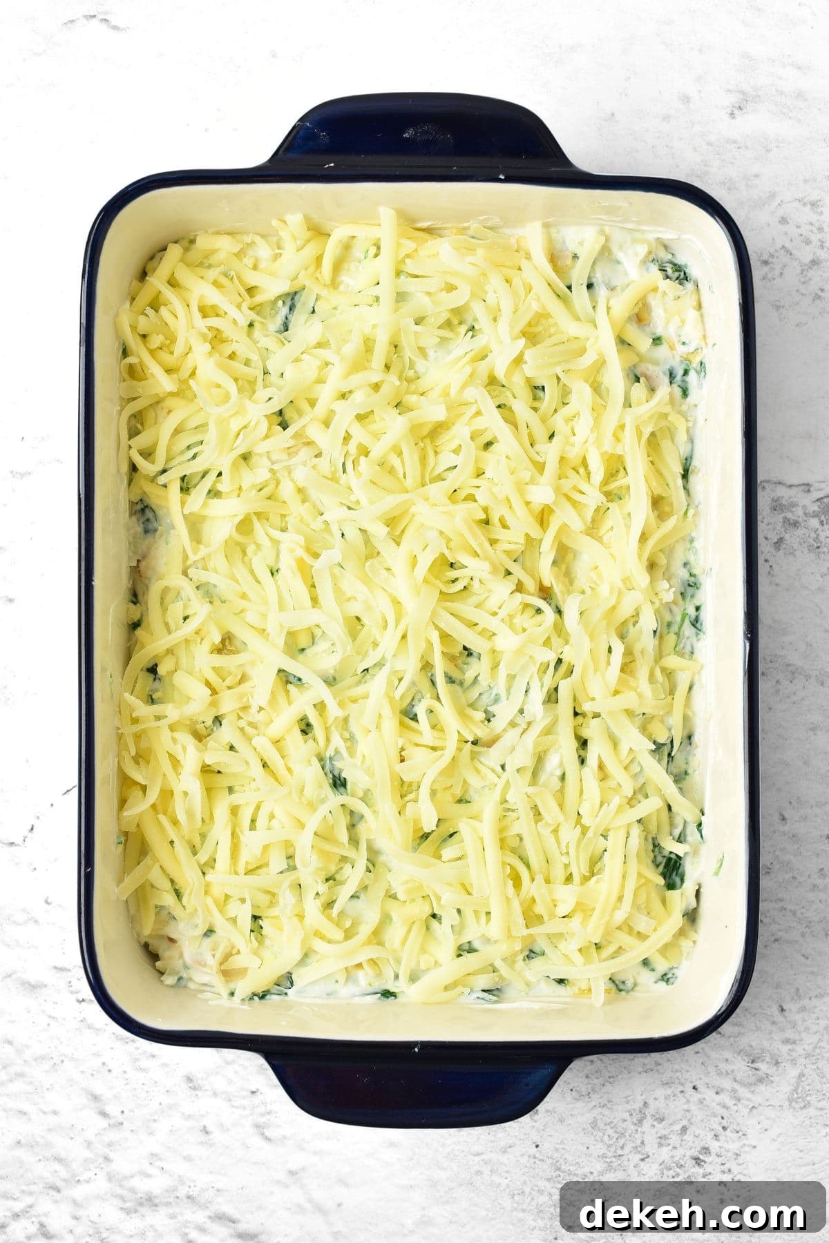 Shredded mozzarella on top of spinach mixture