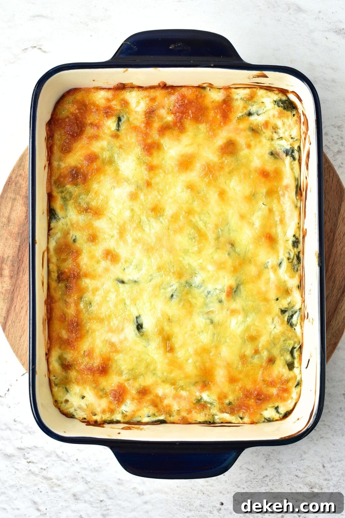 Freshly baked artichoke and spinach dip in baking dish