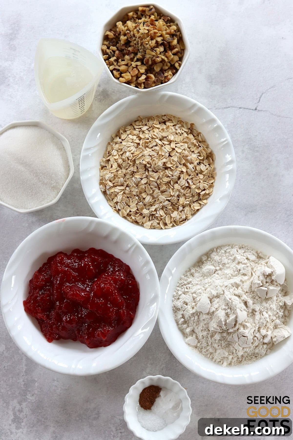 Ingredients needed to make strawberry oatmeal bars on a white marble countertop.