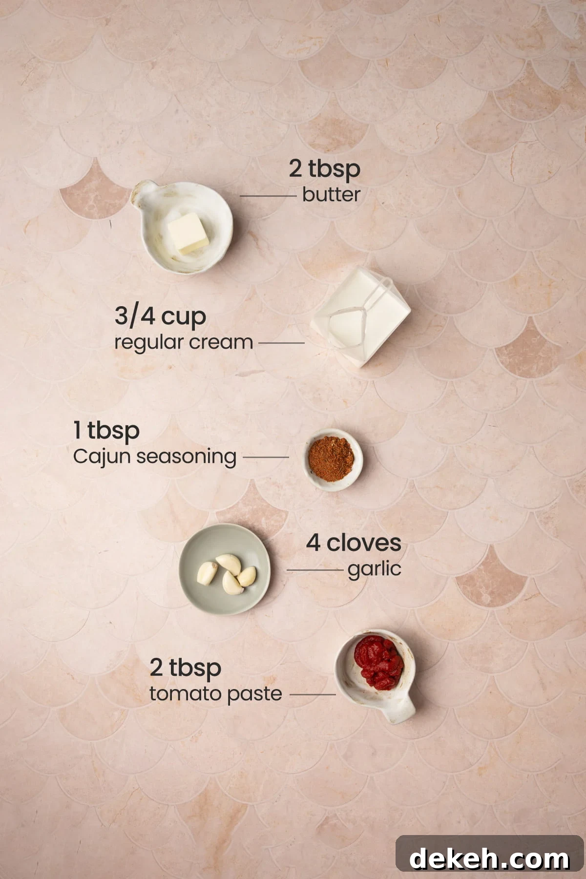 All ingredients needed for Cajun Cream Sauce including butter, cream, Cajun seasoning, garlic, and tomato paste. 