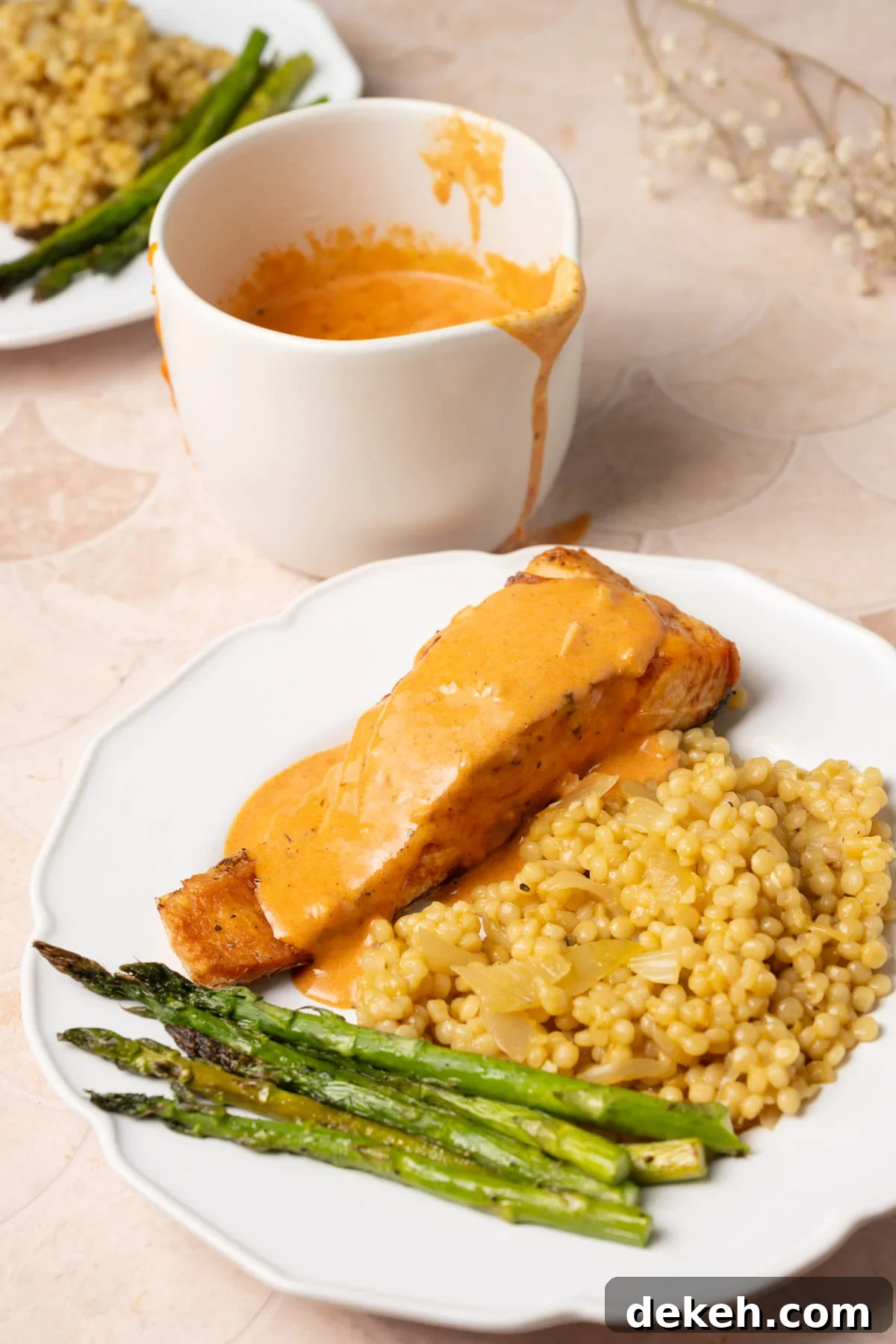 Cajun cream sauce served over a dinner plate with extra sauce in the background. 
