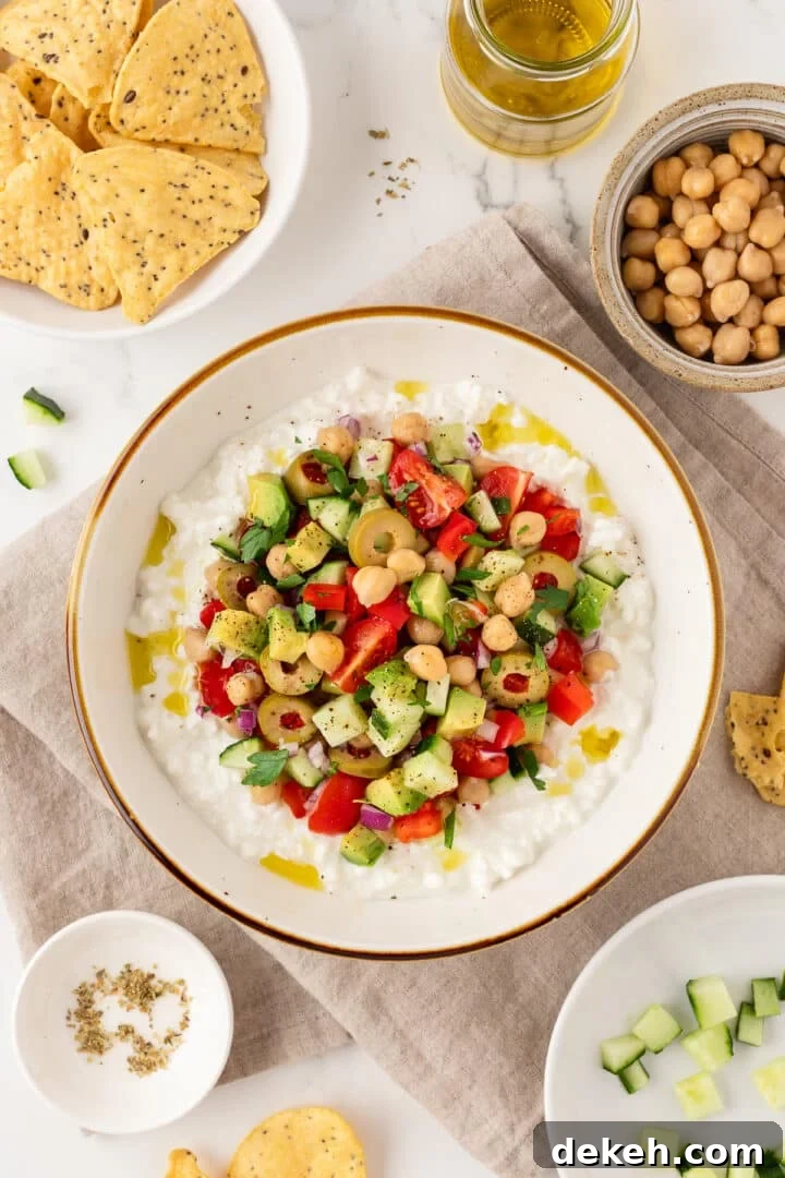 Greek-inspired cottage cheese salad in a bowl next to tortilla chips.