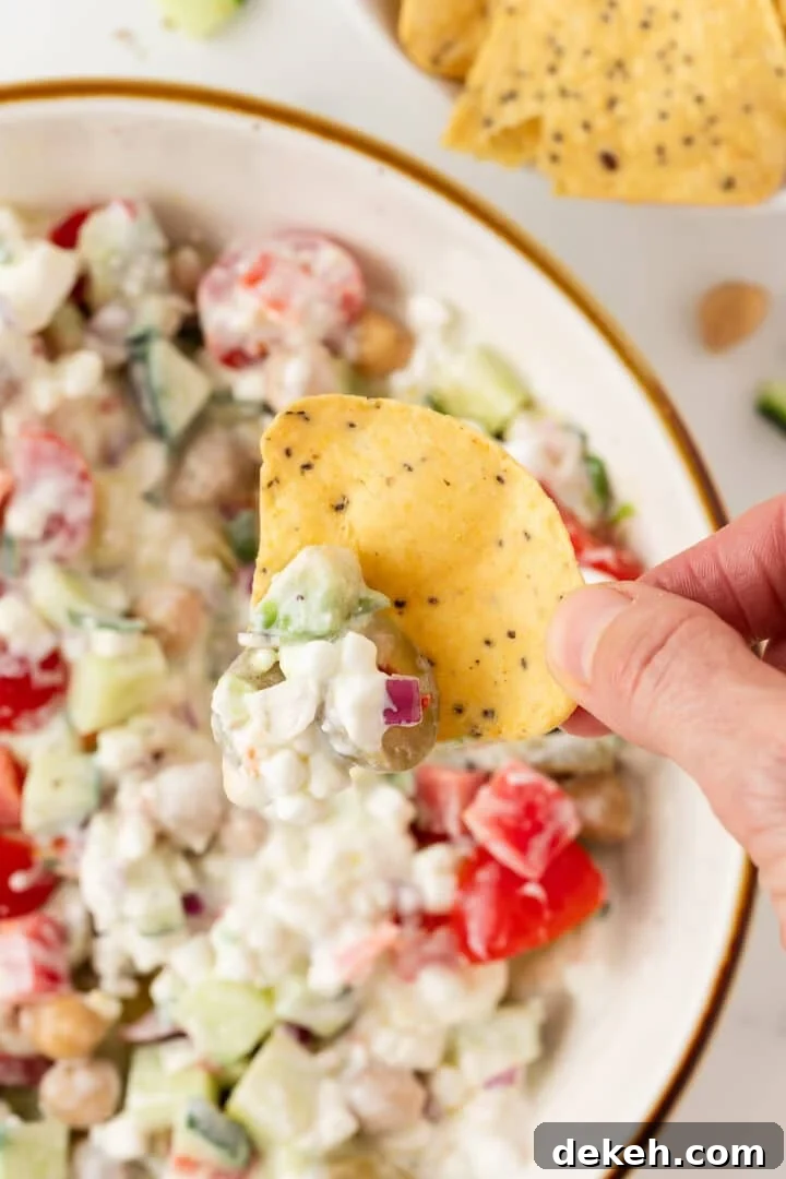 Cottage cheese greek salad scooped onto a tortilla chip.