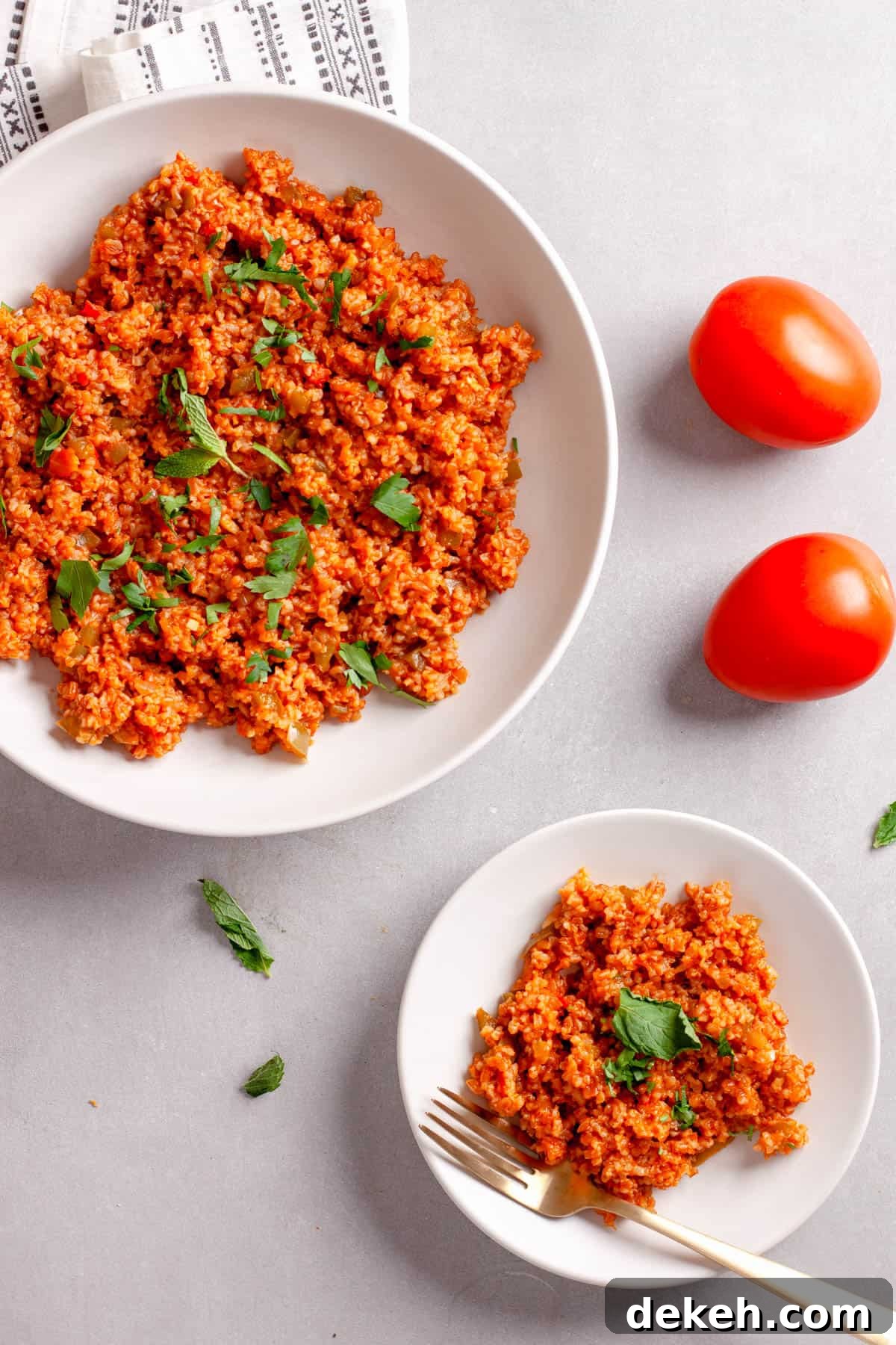 A platter and small plate of bulgur pilaf topped with fresh herbs.