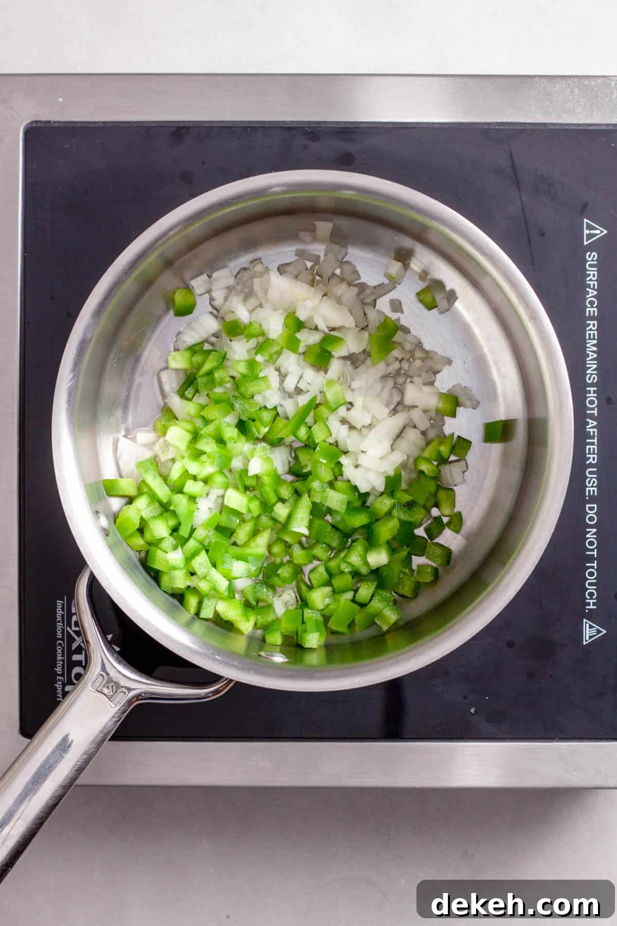 Onions and peppers cooking in a saucepan for bulgur pilaf.