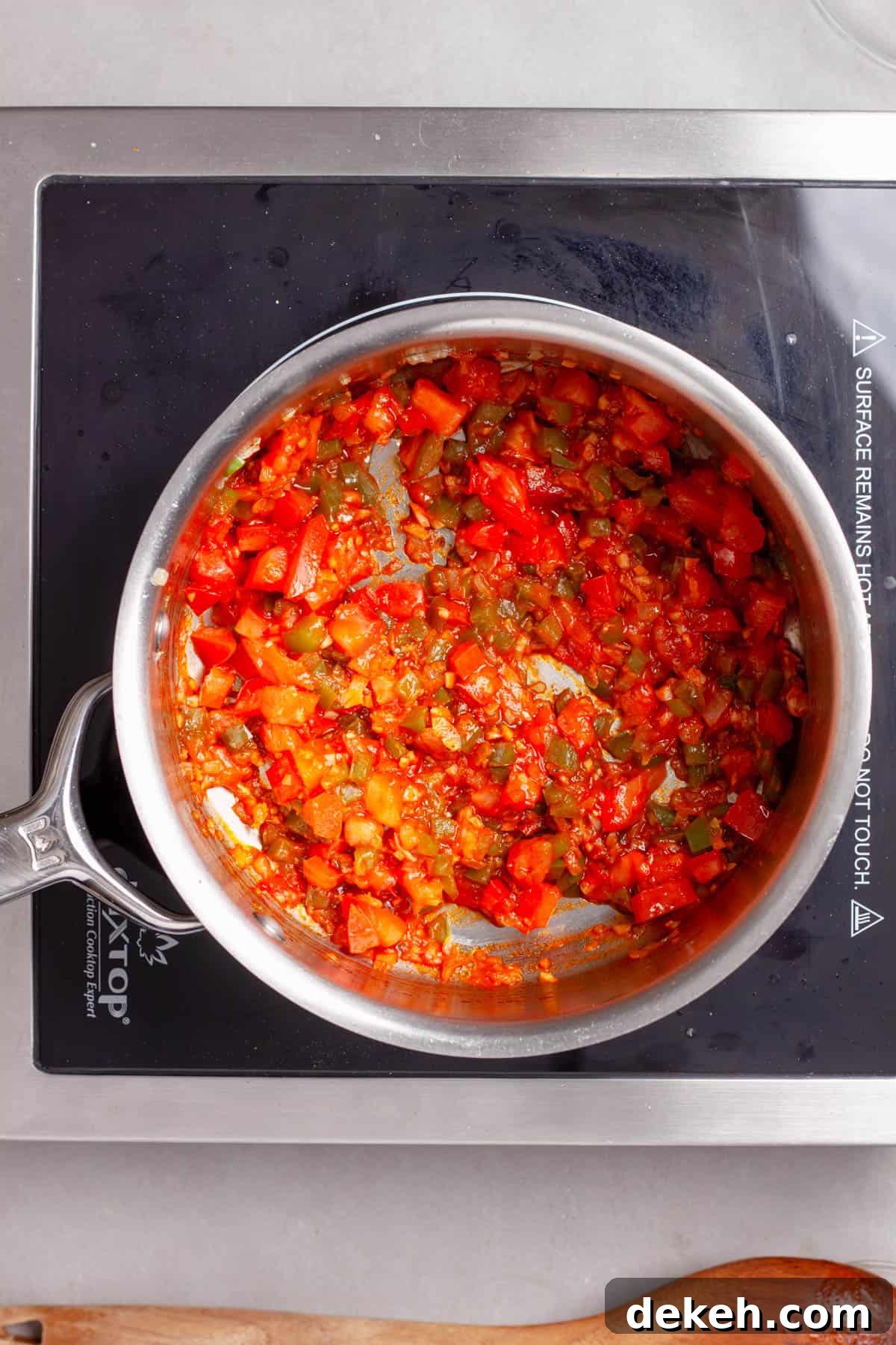 Tomatoes and vegetables cooking in a saucepan for bulgur pilaf.
