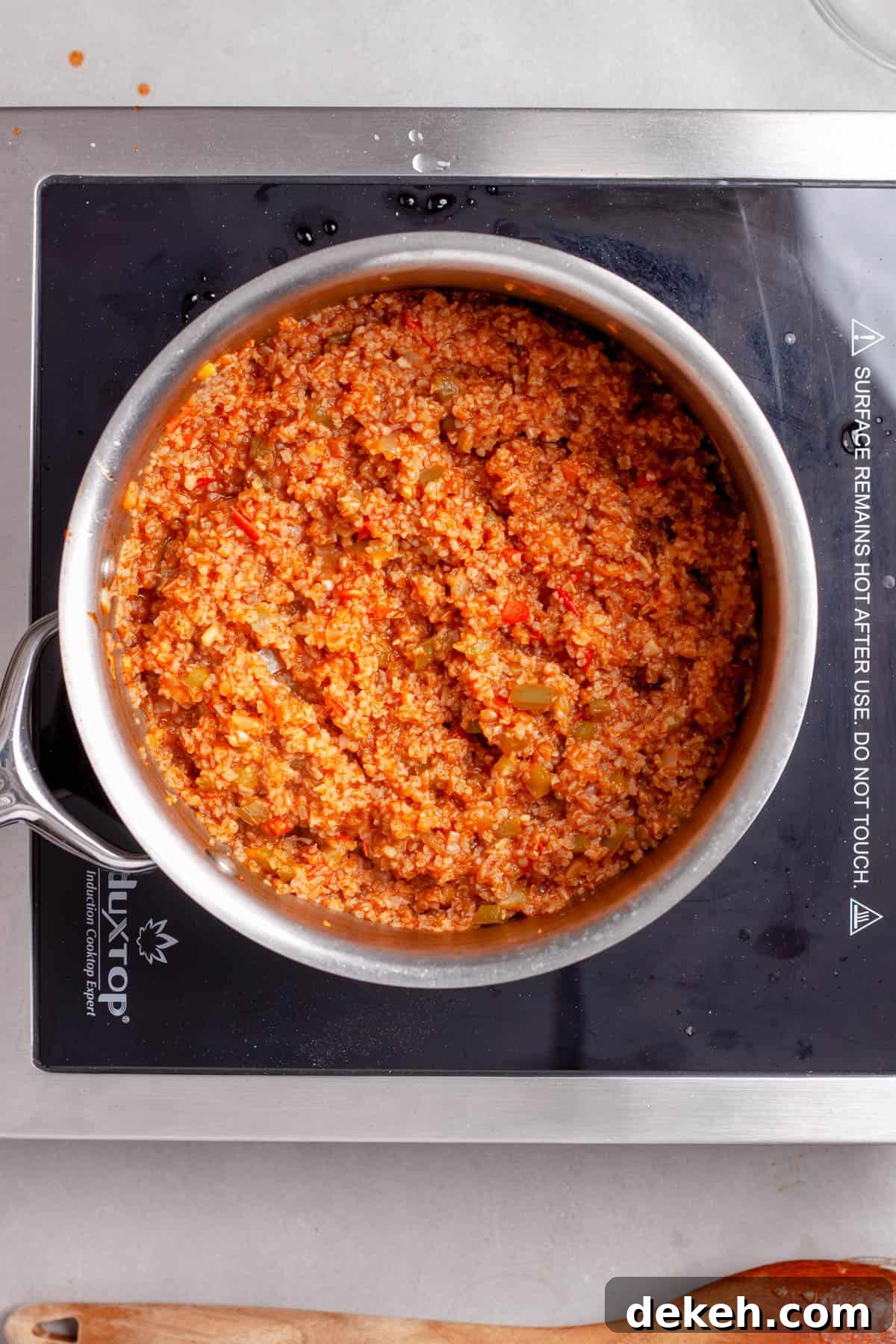 Bulgur pilaf in a saucepan fluffed with a fork.