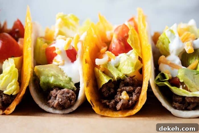 2 cheese shell keto tacos and 2 tortilla keto tacos lined up together filled with meat, lettuce, tomato, sour cream and avocado
