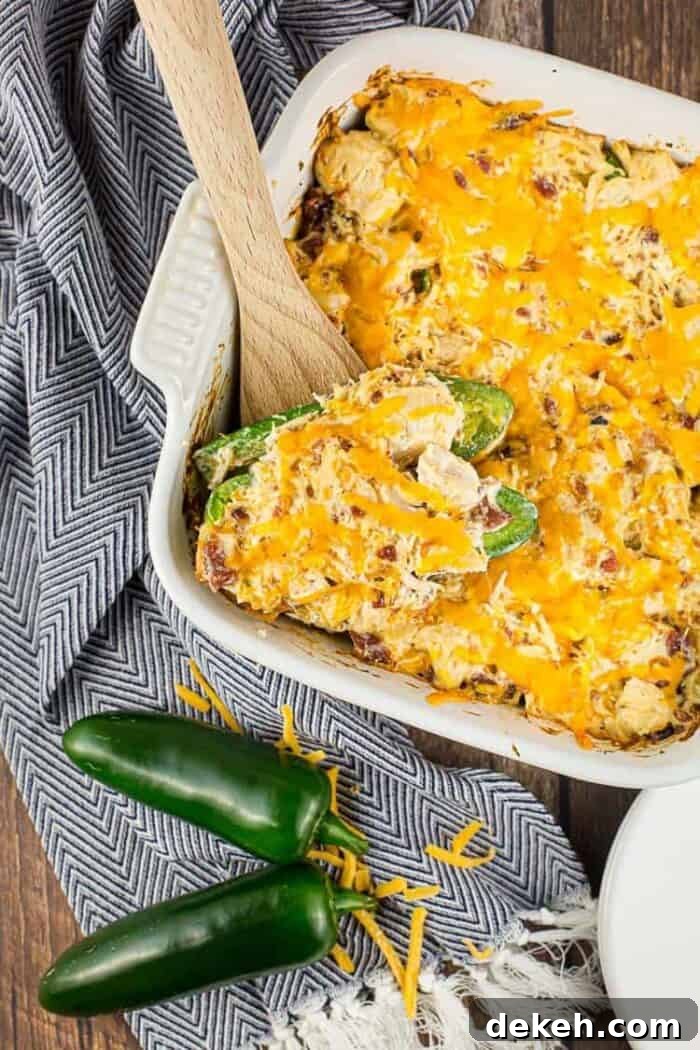 white casserole dish containing keto jalapeño popper chicken casserole next to jalapeños