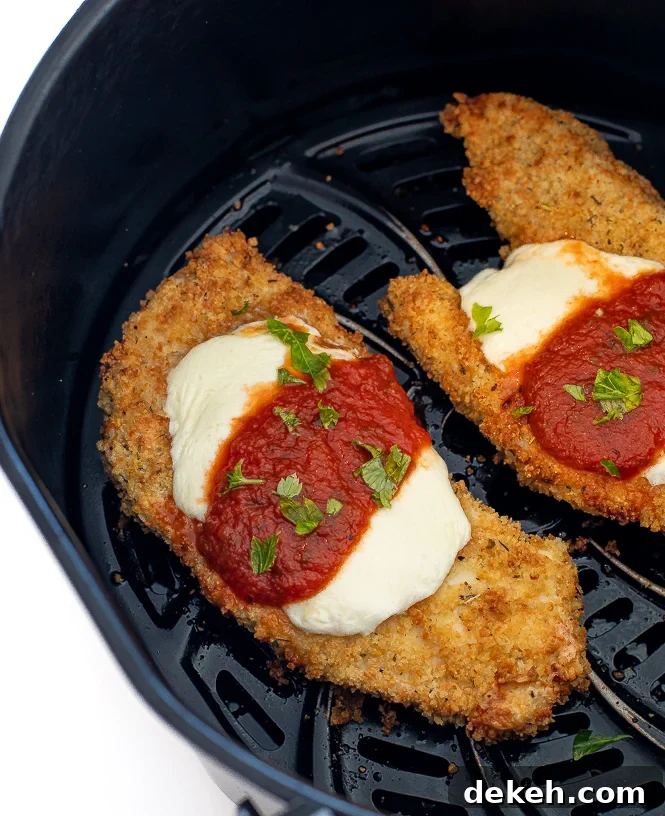 Chicken parmesan in the basket of an air fryer. 